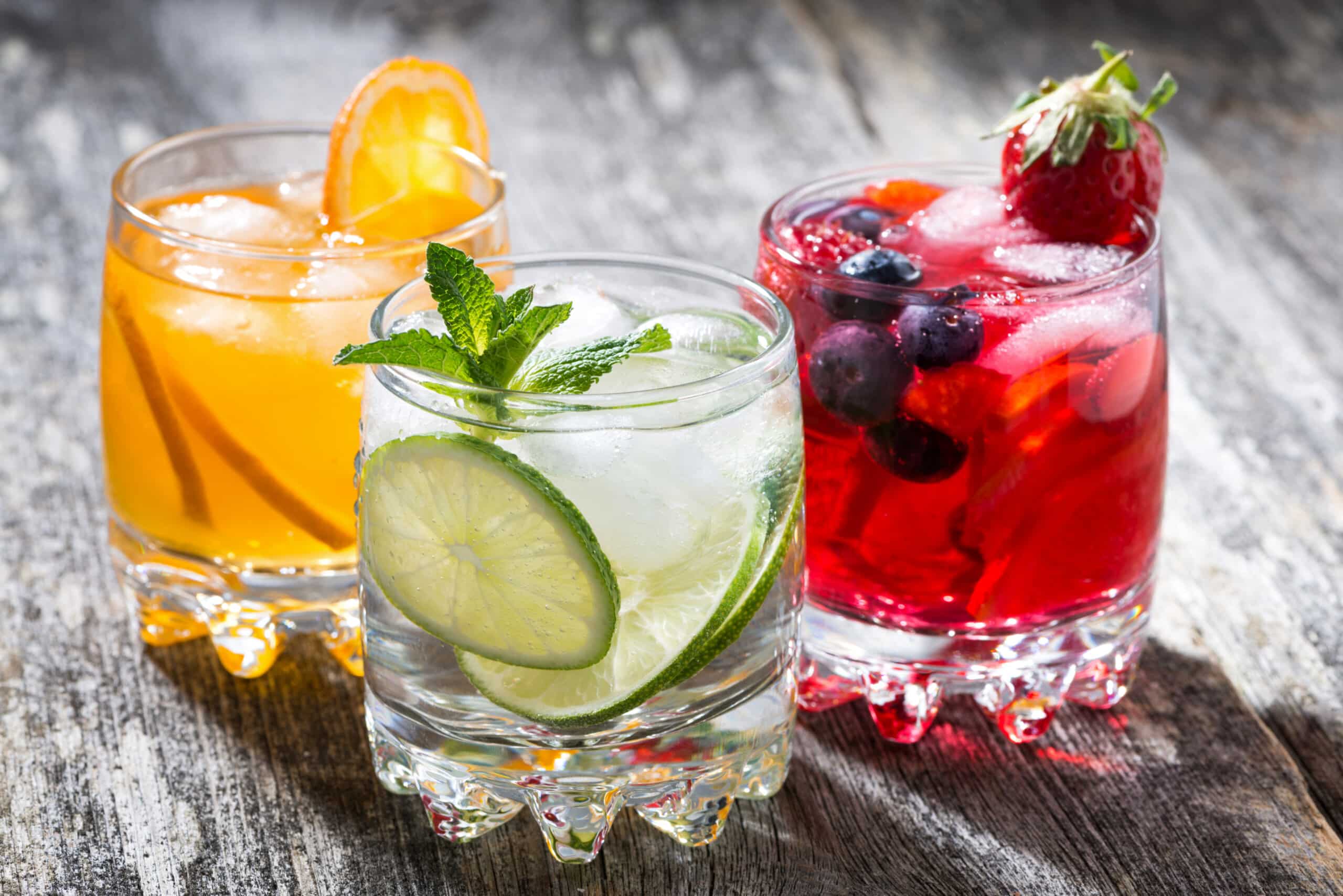 assortment of fresh iced fruit drinks on wooden background assortment of fresh iced fruit drinks on wooden background, horizontal